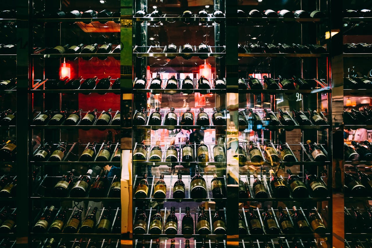 about-03 Rows of wine bottles elegantly displayed on shelves at an upscale bar, creating a luxurious ambiance.